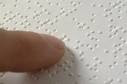 this is a picture of a finger going over brail