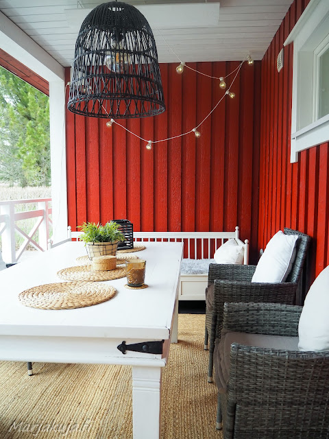 Punavalkoisen puutalon terassin sisustus, joten tervetuloa kesä