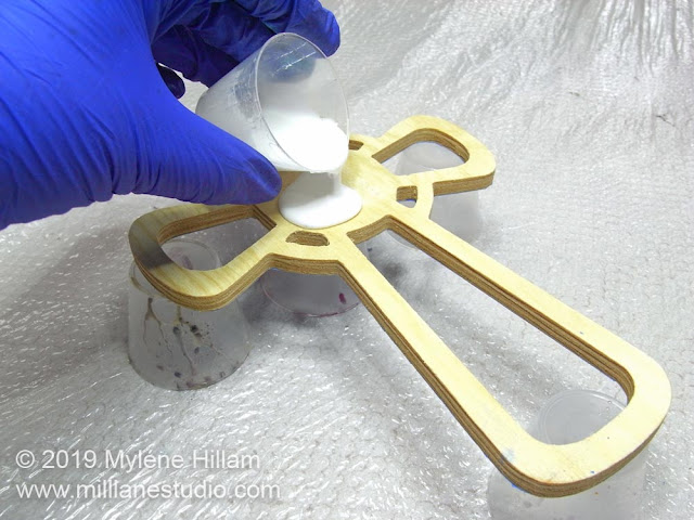 Pouring white resin onto the centre of the cross.