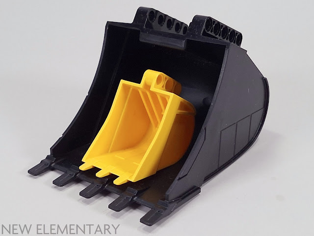 a large yellow technic lego digger bucket sitting within an absolutely massive black one