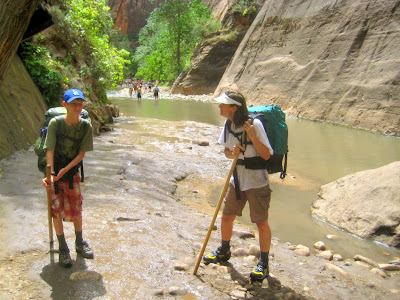 Hikers in Zion Narrows with hiking sticks