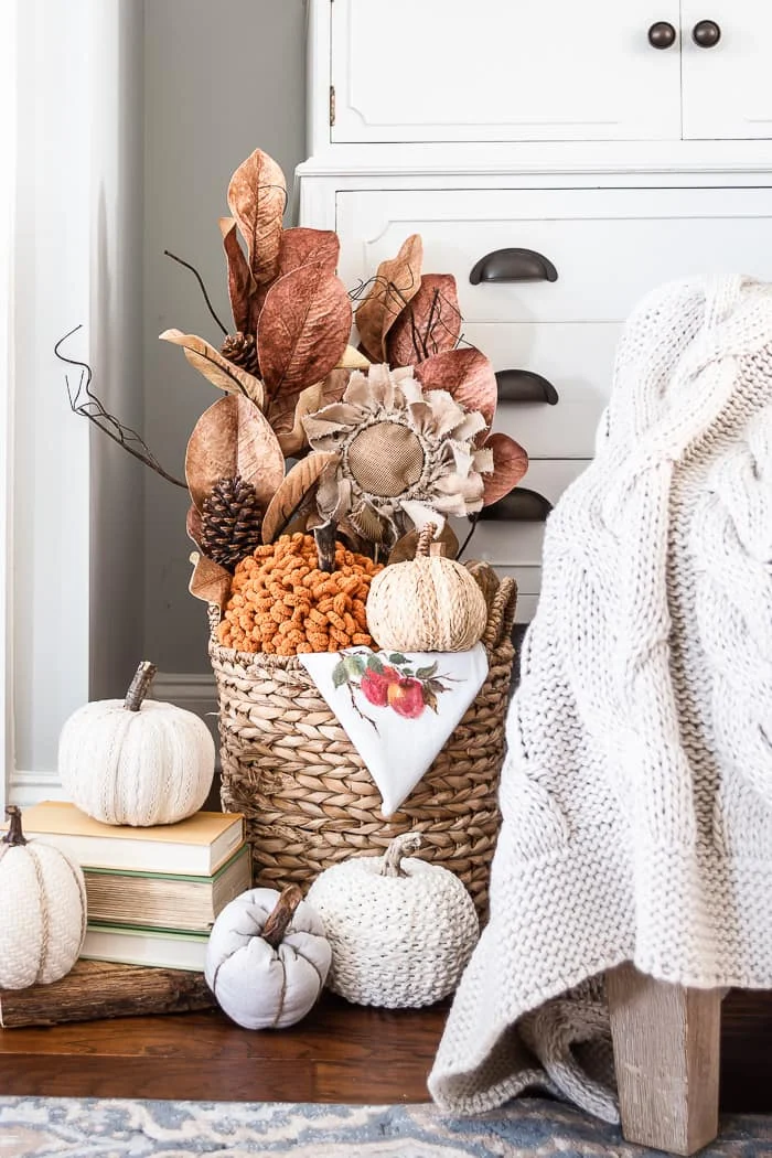 basket filled with pumpkins and leaves, bookstack, neutral pumpkins