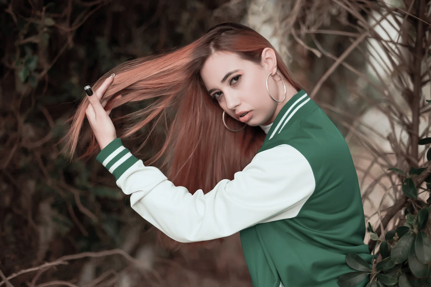 woman is touching her long, straight hair