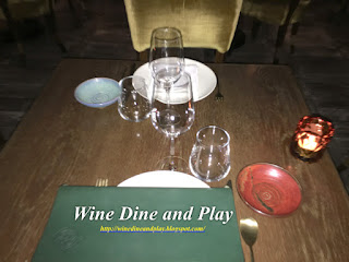 Wine glasses and colored bread plates line the tables at COYA restaurant in Dubai