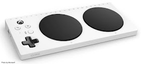 Image of Microsoft's Xbox Adaptive Controller. The device is white, features two, large, black buttons that are side-by-side on the right, and a black, directional pad on the left