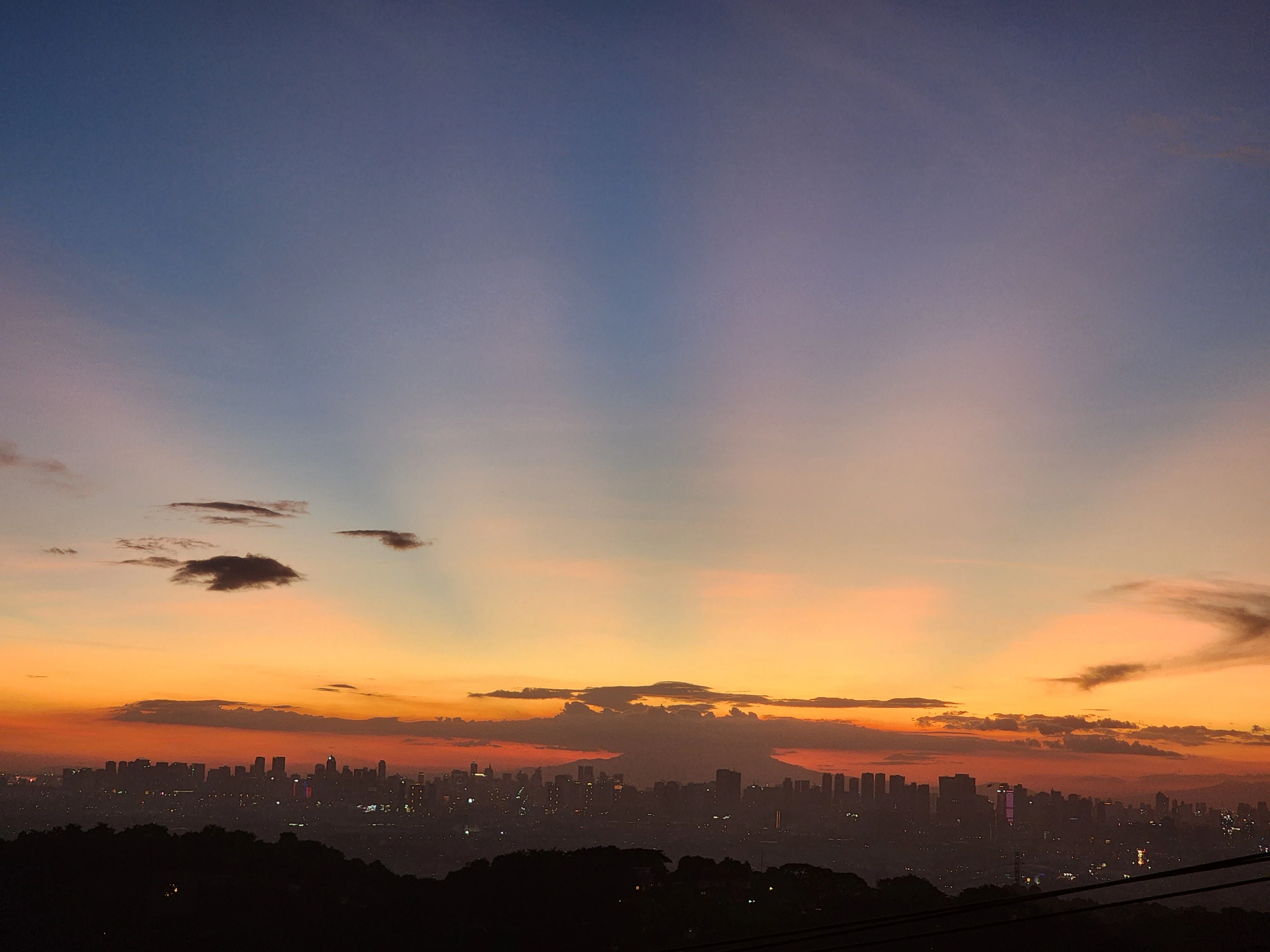 Orange sunrays at sunset overlooking Metro Manila skyline