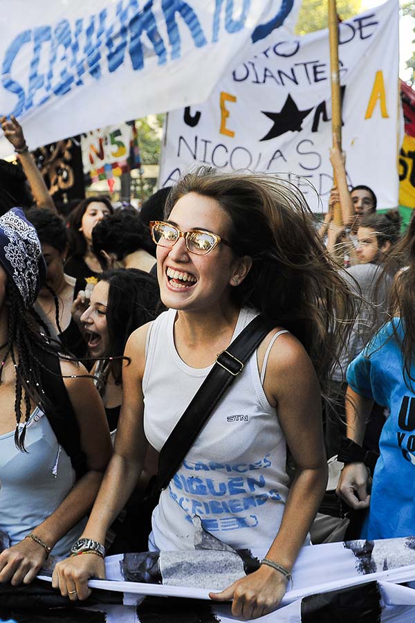 mujer rie en una manifestacion social en memoria de la noche de los lapices