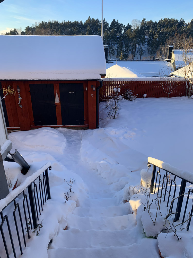 Steps, a lot of snow and a red storage building