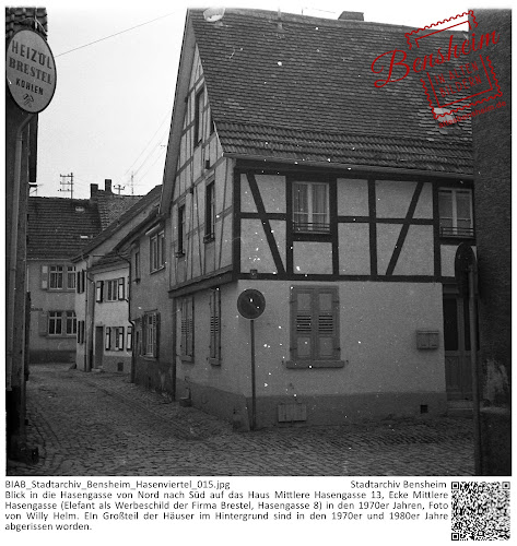 BIAB_Stadtarchiv_Bensheim_Hasenviertel_018.jpg; Stadtarchiv Bensheim; Blick in die Hasengasse von Nord nach Süd auf das Haus Mittlere Hasengasse 13, Ecke Mittlere Hasengasse (Elefant als Werbeschild der Firma Brestel, Hasengasse 8) in den 1970er Jahren, Foto von Willy Helm. EIn Großteil der Häuser im Hintergrund sind in den 1970er und 1980er Jahre abgerissen worden.