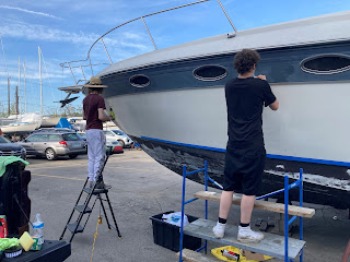 Person applying boat wrap graphics in Livonia