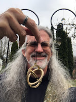 John holding up a brass pocket sundial.