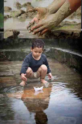 A Child In Pond With Paper Boat