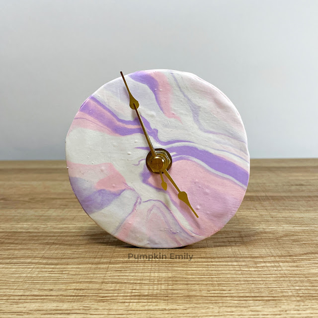 A pink, white, and purple marble desk clock made out of polymer clay