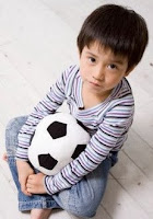 Photo of Ted as a boy with a ball