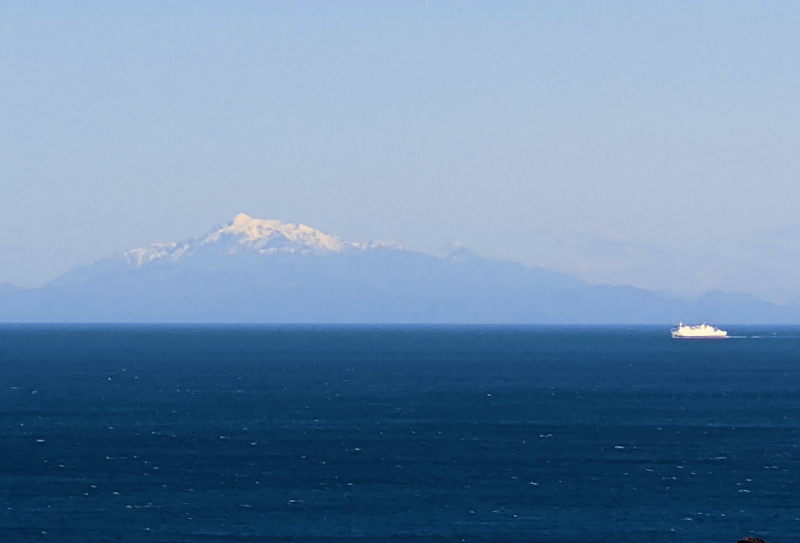 Out towards the snowy peaks of the South Island across Cook Strait with Interisland ferry making an appearance on the horizon