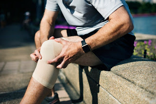 A person with a knee wrap after surgery