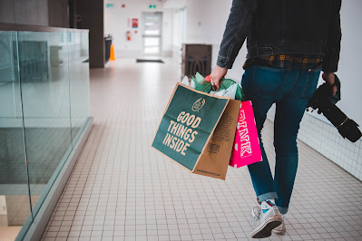 Hombre con bolsas de la compra caminando por un centro comercial