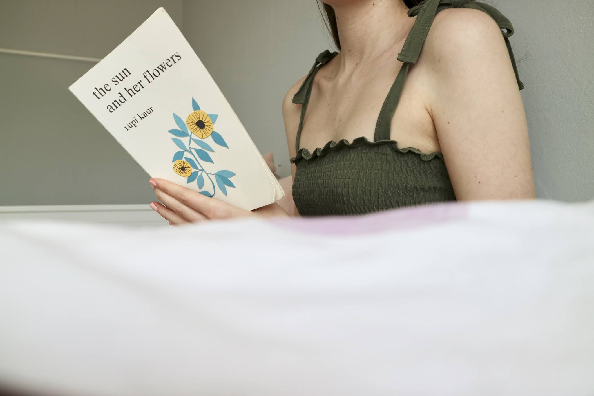 Girl reading The Sun and Her Flowers by Rupi Kaur