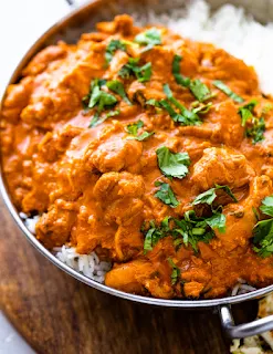 serving butter chicken on the top of steam rice