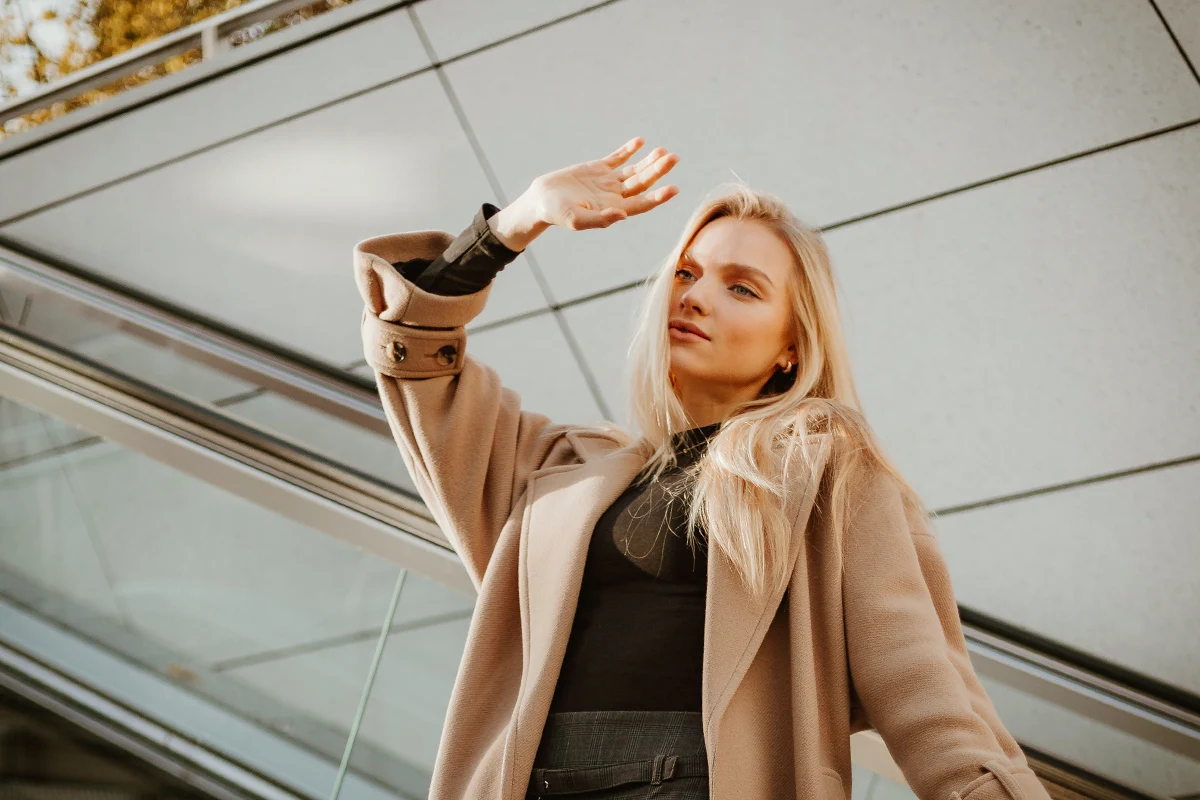 a beautiful woman in a fall outfit posing on the street