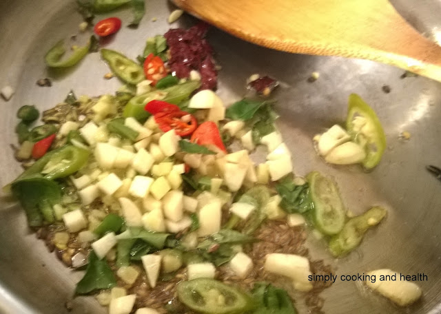 Adding curry leaves green chili, red chili,garlic and ginger 