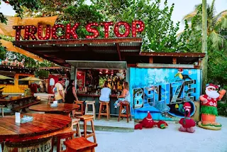 A photo of a couple at a truck stop with truck stop on front of the building