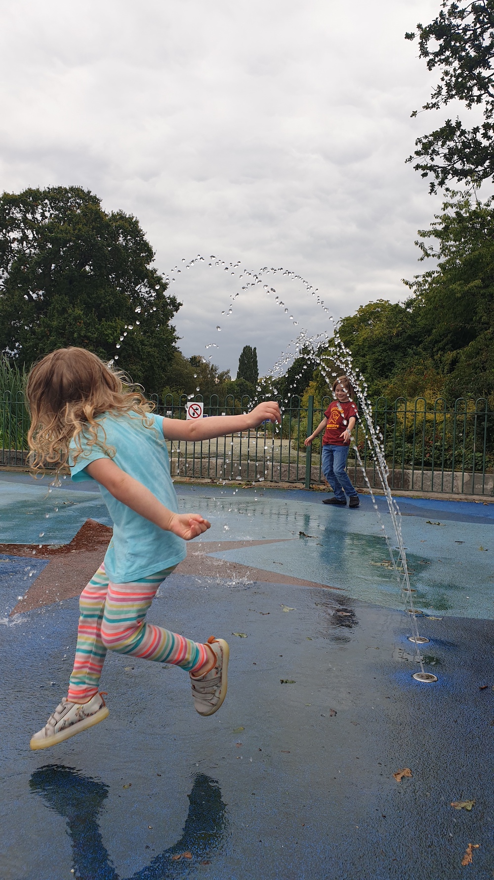 a picture of a child jumping at a splash park