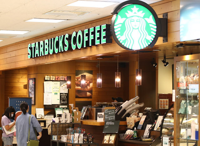 Customers wait for their beverages at a Starbucks store in Seoul. | Pic by Koreaherald