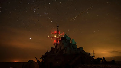 US Navy Destroyer just sailing in the night time sky.