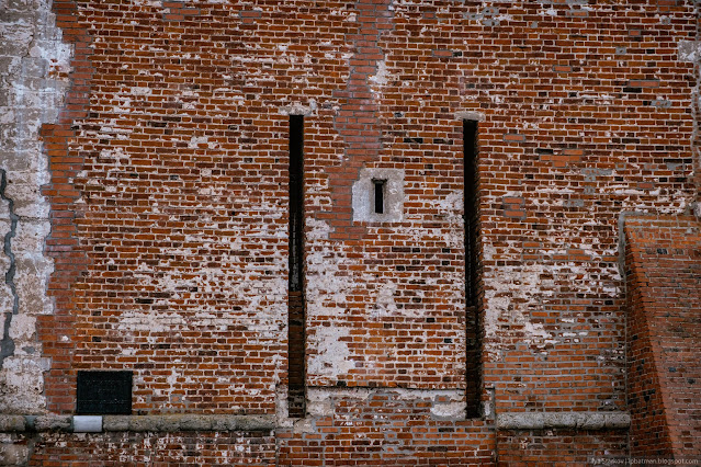 Вертикальные прорези в стене башни из красного кирпича