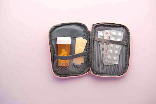 A first aid kit laid open on the table with medication on display