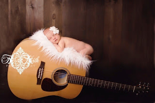 Gambar bayi lucu tidur pulas di atas gitar