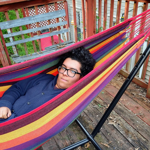 person in a rainbow striped hammock