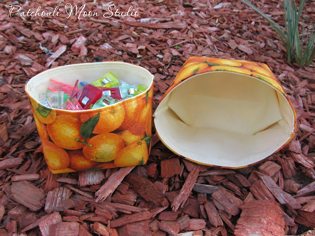 Fabric baskets in oranges fabric print. One shown on its side.