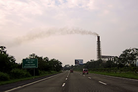 factory spewing smoke in the country-side