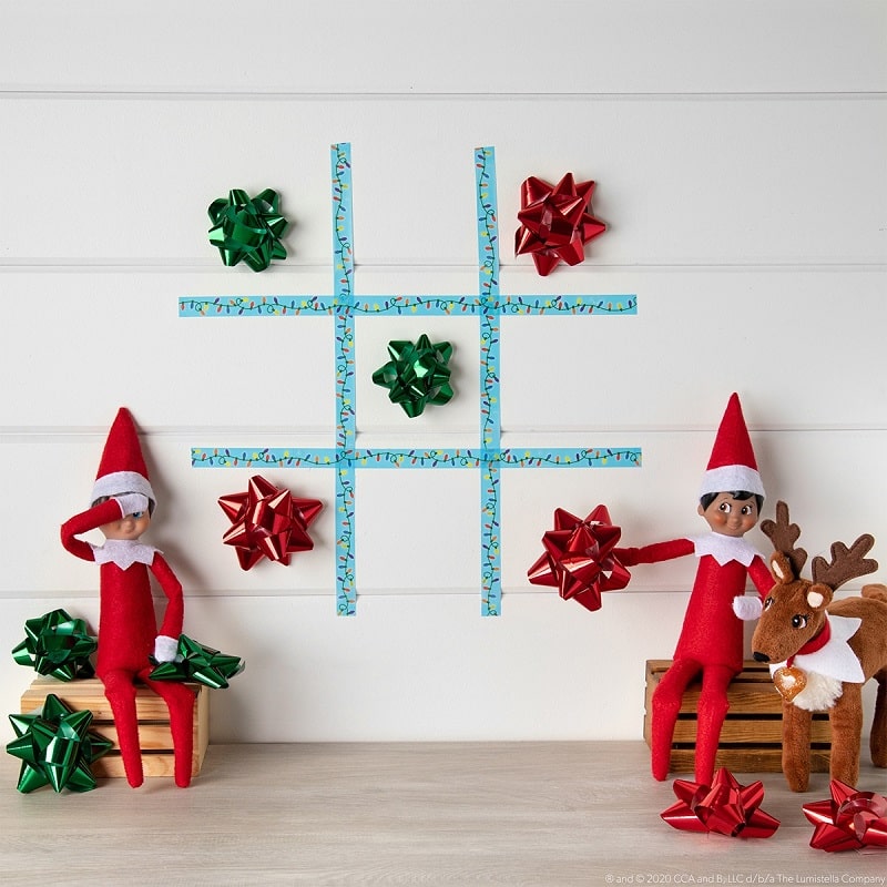 elves playing tic tac toe with christmas bows