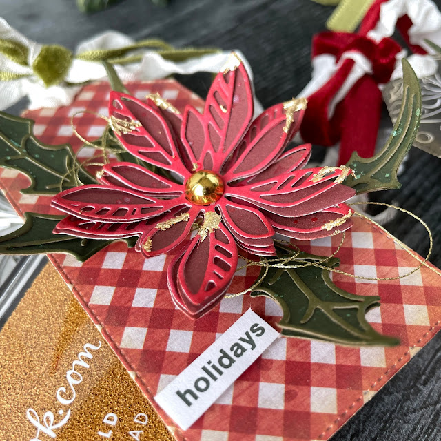 DIY Poinsettia Christmas gift tags made with: Tim Holtz Sizzix poinsettia seasonal sketch, holiday paper stash, cook kraft stock, rustic wilderness distress ink, crinkle ribbon, velvet trim; Scrapbook.com pops of color cherry pie, A2 smooth christmas cardstock, gold metallic ink, stickers, smart glue; WeR gold thread; Priam gold metallic flakes