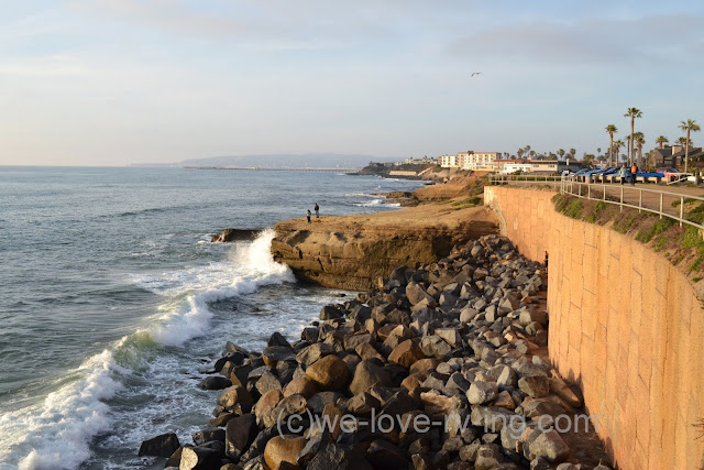 The rocky cliffs can be seen as the waves crash along the shoreline