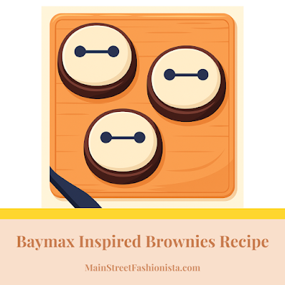 A flat, digital illustration of three round brownies decorated to look like Baymax from Big Hero 6. Each brownie is frosted with smooth white icing and features Baymax's signature minimal face—two black eyes connected by a straight black line. The brownies are arranged neatly on a wooden surface.