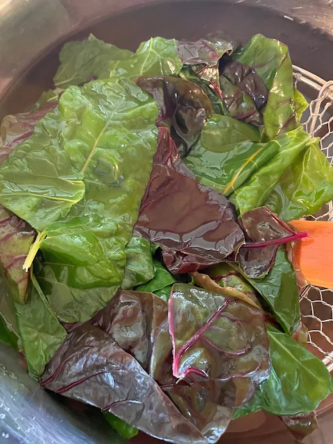 Swiss chard leaves in an ice water bath.