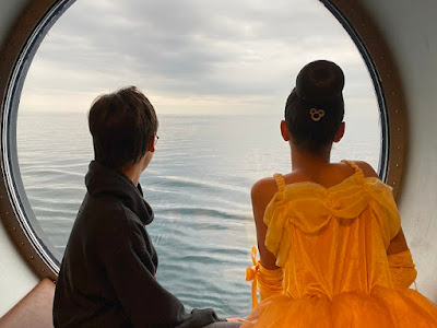 Children looking through a porthole on a Disney cruise ship