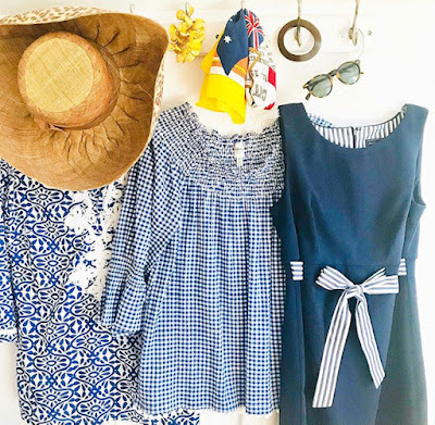 a hat and blue and white outfits hanging on a rack