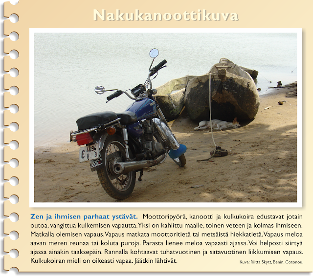 Joen rannassa moottoripyörä ja iso yhdestä puusta koverrettu kanootti, jonka varjossa makaa kulkukoira.