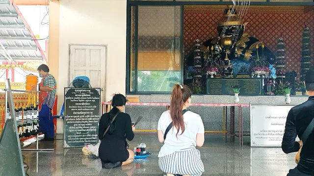 자신의 수호 부처상에 기도하는 아내
