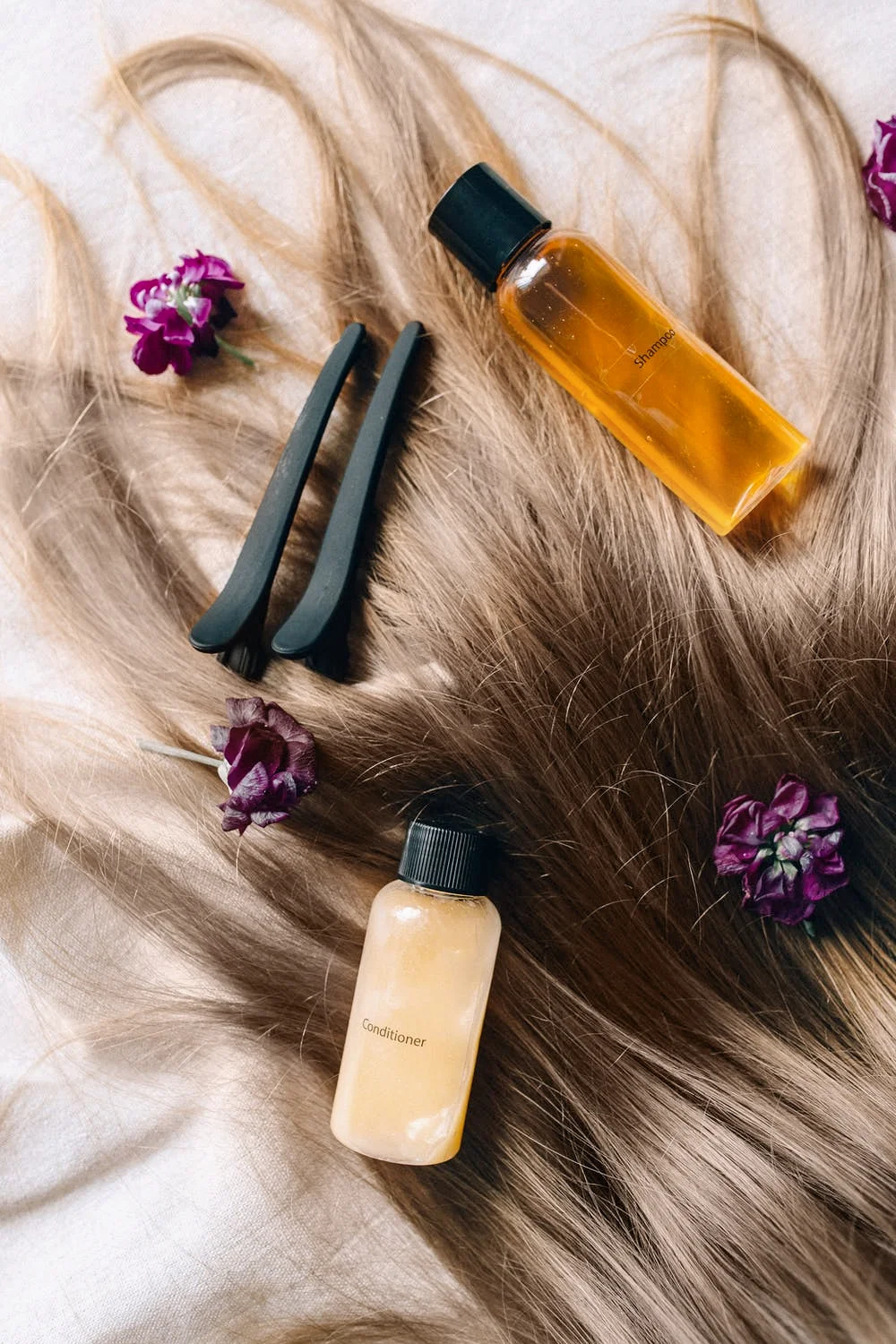 a bunch of hair care products laying on top of a long hair