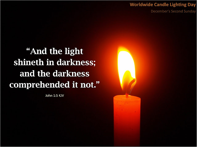 Darkness lit by a single candle. A verse overlay reads: And the light shineth in darkness; and the darkness comprehended it not." John 1:5 KJV. Worldwide Candle Lighting Day is December's 2nd Sunday.
