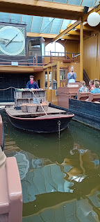 Een boot waarop manden met uien en zakjes andere groenten ligt stil onder de grote veilingklok.