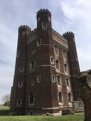 photo of red brick castle tower with turrets on each corner