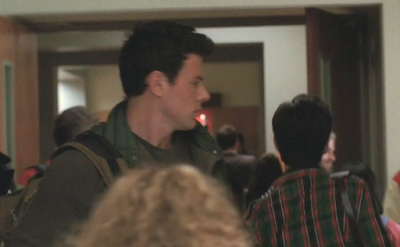 Finn looking back at Kurt in a school hallway