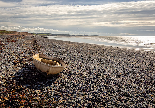 Photo of a small boat washed up on the shore at Maryport